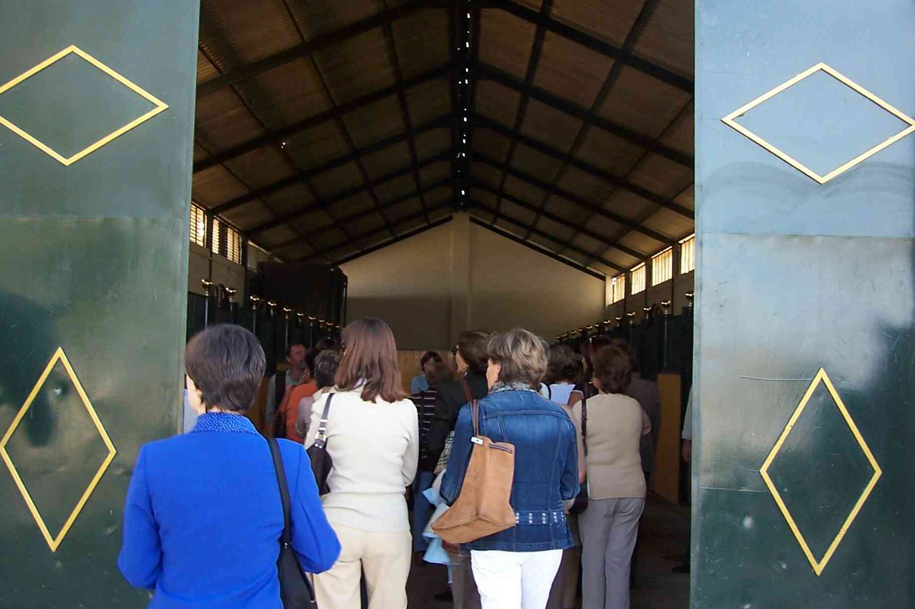 Grupo de personas en la entrada de un establo